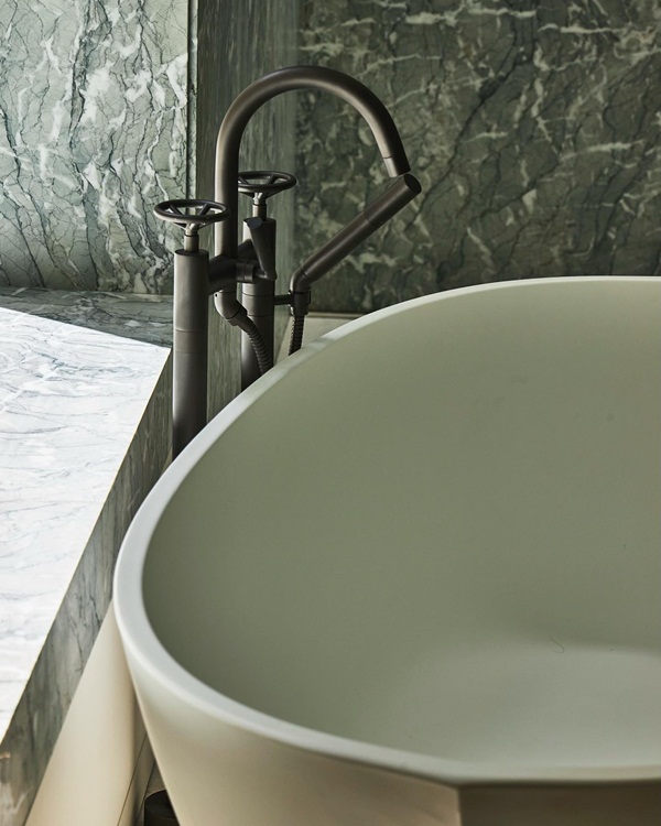 Freestanding bathtub and filler in Kelly Wearstler's bathroom, awash in the gentle embrace of natural light.